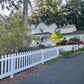 White house with a Weatherables Plymouth white vinyl picket fence and trees in the background
