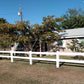 House with a Weatherables 2-rail white vinyl ranch fence and trees in the background