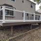 Wooden deck with Weatherables Bolton white vinyl deck railing and gazebo attached to a house.
