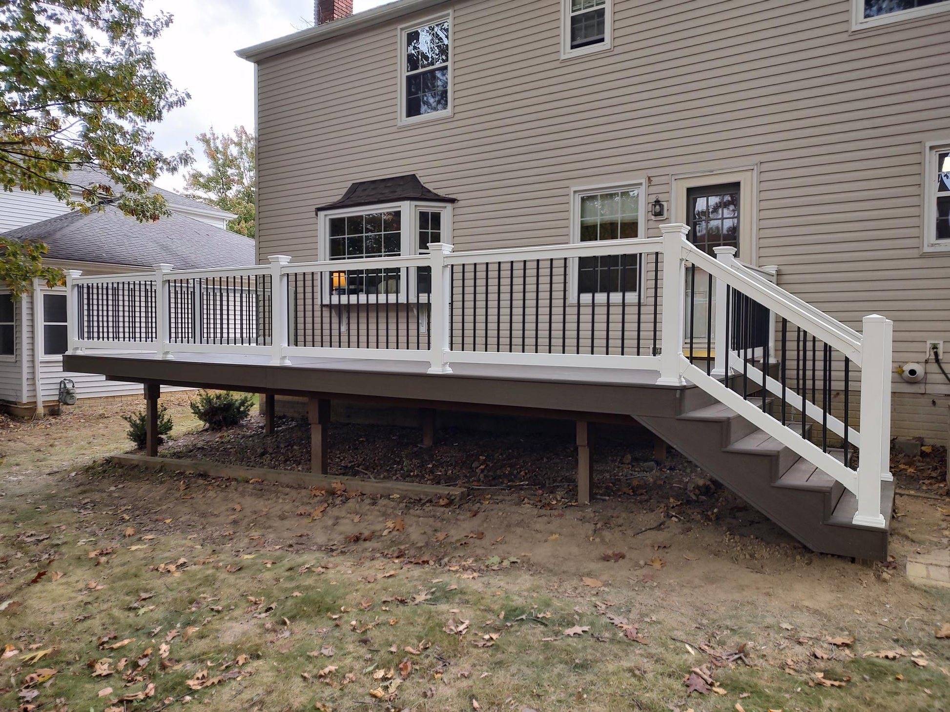 House with a newly constructed deck, Weatherables Bolton white vinyl deck railing and staircase
