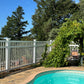 Pool area with Weatherables Neptune white vinyl pool fence and greenery