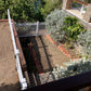 Garden with plants and a Weatherables Hartford white vinyl picket fence, viewed from above