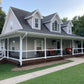 Two-story house with a large porch featuring Weatherables Birmingham white vinyl porch railing and greenery around