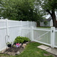 Weatherables Hartford white vinyl picket fence with garden and pathway in a residential backyard