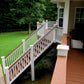 Wooden deck with Weatherables Bristol white vinyl deck and stair railings leading to a grassy area
