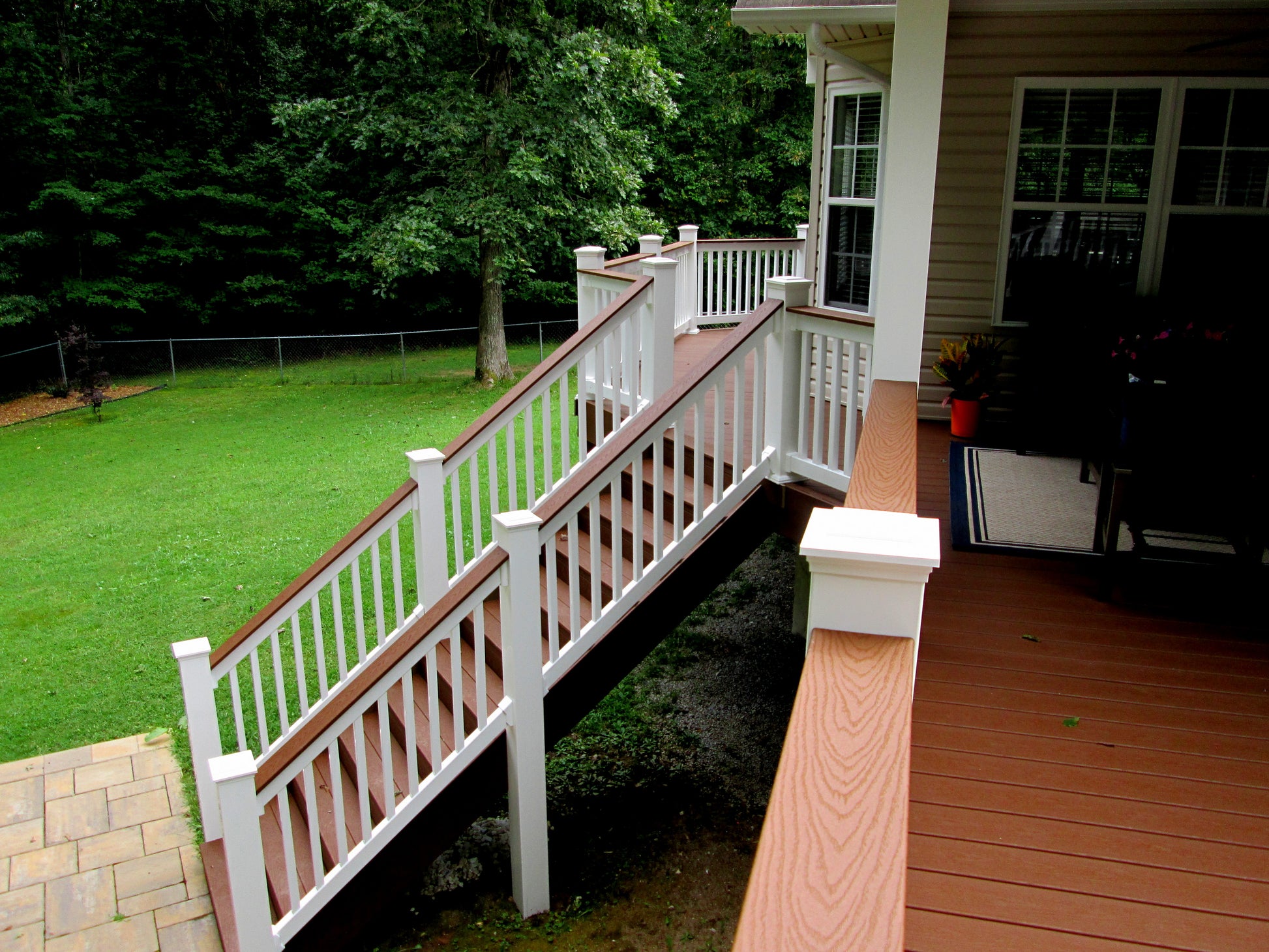 Wooden deck with Weatherables Bristol white vinyl deck and stair railings leading to a grassy area