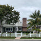Stylish house with a Weatherables Barrington white vinyl picket fence and palm trees on a cloudy day.