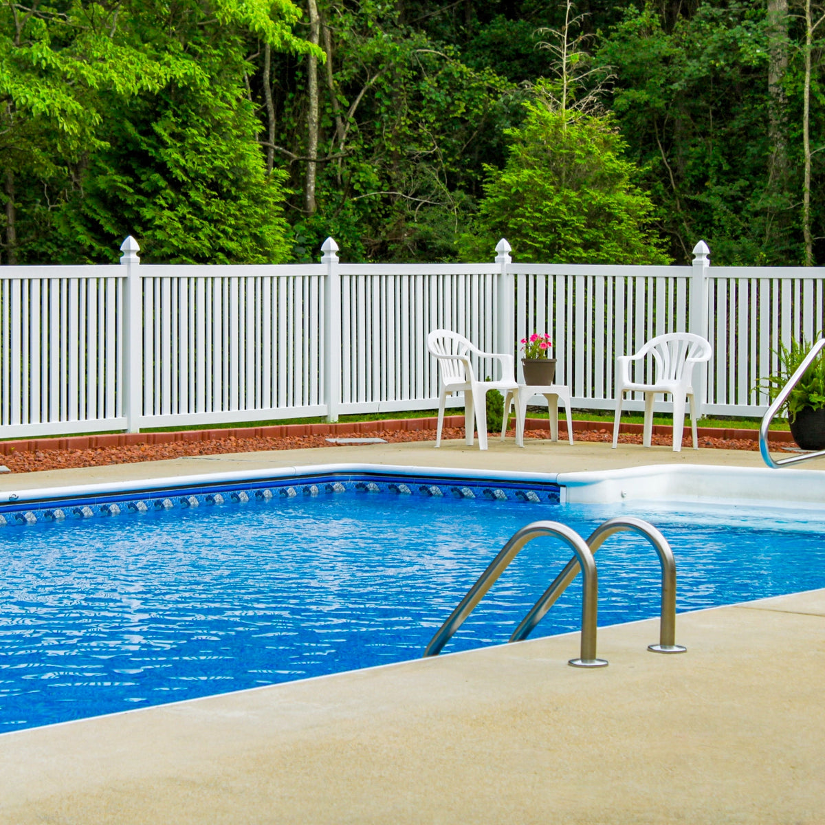 Sarasota pool fence surrounding a nice blue pool with a ladder. 