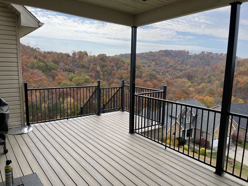 Deck with Weatherables black aluminum railing overlooking a scenic view of trees with autumn colors.