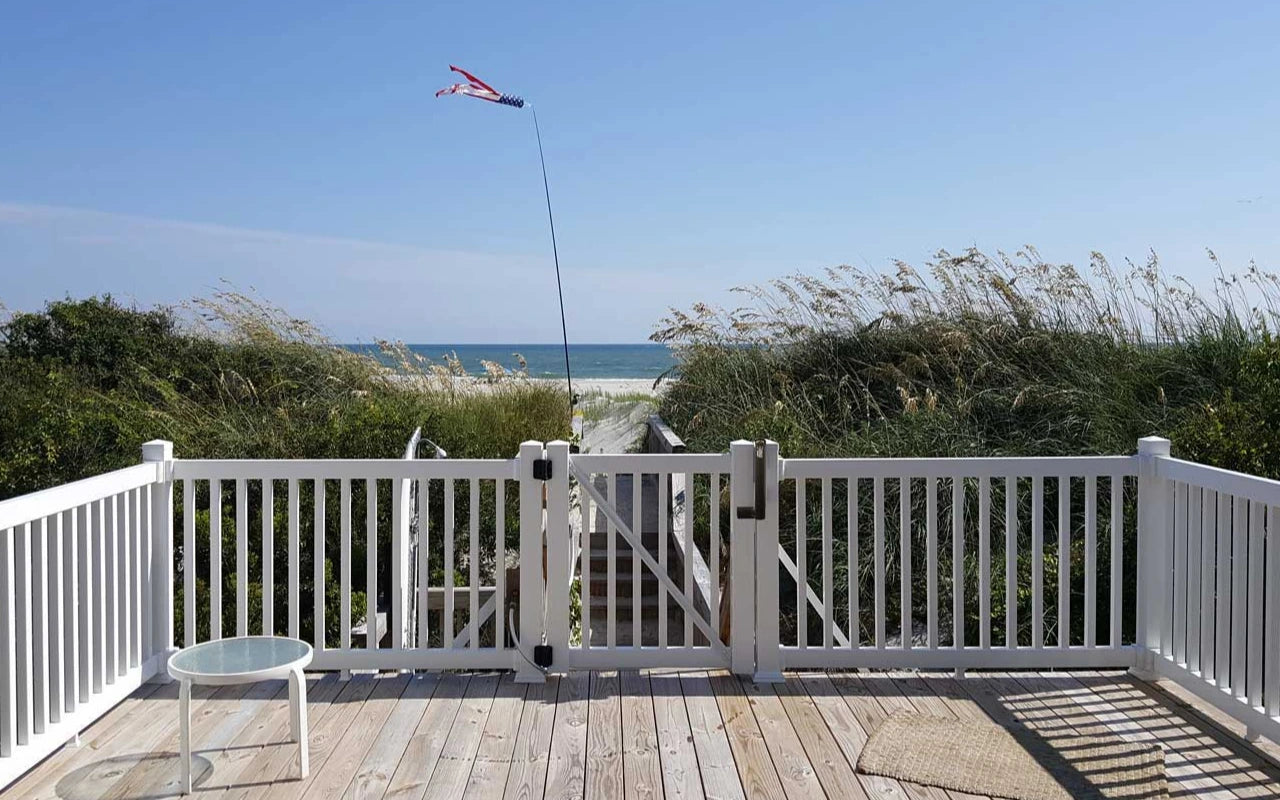 Deck with Weatherables white Greenwich vinyl railing overlooking a beach and ocean