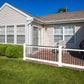 Backyard with Weatherables Jefferson white vinyl deckboard railing on a patio, lawn chairs, and a barbecue grill on a sunny day.