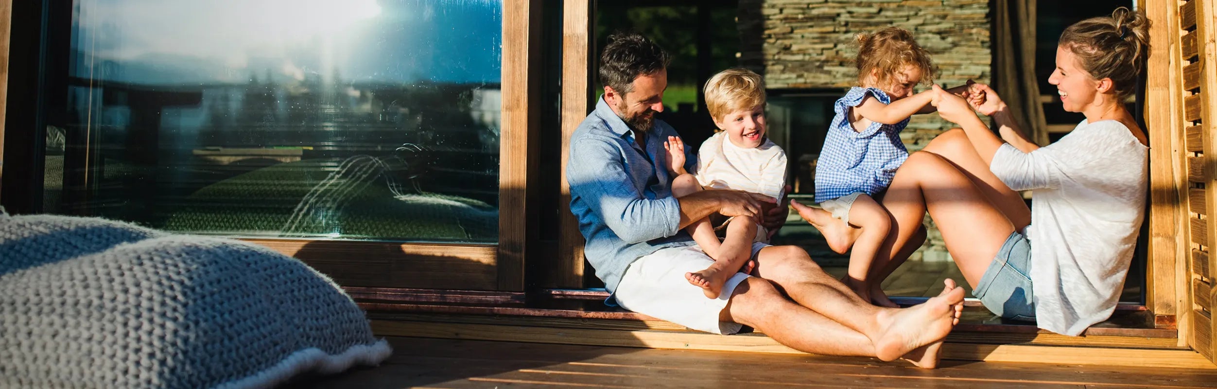 Family sitting on a wooden deck with a scenic view