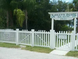 White picket fence with a sign reading 'Bailey's Blues' in a residential area.