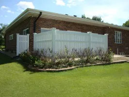Brick house with a white picket fence and green lawn