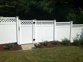 White vinyl fence with lattice top design in a garden setting